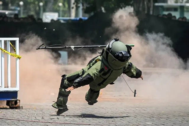 A police officer from an explosive disposal unit takes part in a security drill ahead of next year's general election in Sidoarjo, East Java, on August 23, 2023. (Photo by Juni Kriswanto/AFP Photo)