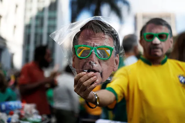A street vendor sells a mask of Jair Bolsonaro, far-right lawmaker and presidential candidate of the Social Liberal Party (PSL), in a demonstration in Sao Paulo, Brazil, October 21, 2018. (Photo by Nacho Doce/Reuters)