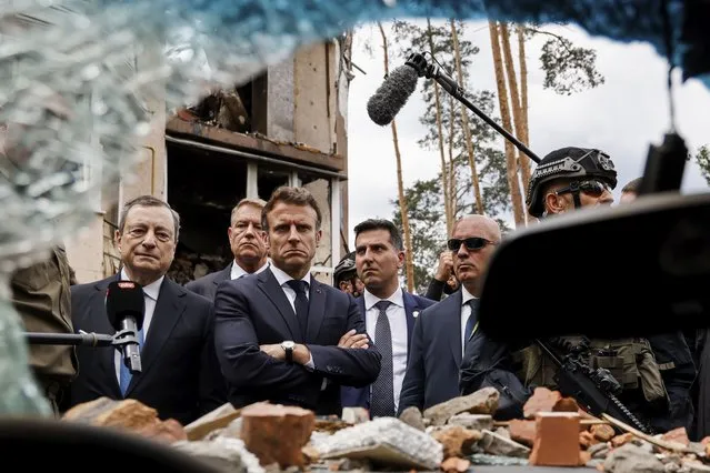 Italian Prime Minister Mario Draghi, left, and French President Emmanuel Macron watch debris as they visit Irpin, outside Kyiv, Thursday, June 16, 2022. The leaders of France, Germany, Italy and Romania arrived in Kyiv on Thursday in a show of collective European support for the Ukrainian people as they resist Russia's invasion, marking the highest-profile visit to Ukraine's capital since Russia invaded its neighbor. (Photo by Ludovic Marin, Pool via AP Photo)