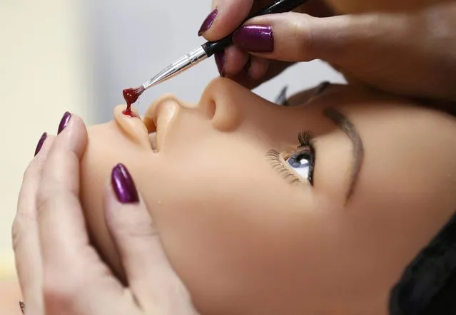 Raphaela, an employee at the Dreamdoll company, works on the makeup of a silicone dream doll in their workshop in Duppigheim near Strasbourg, December 2, 2014. (Photo by Vincent Kessler/Reuters)