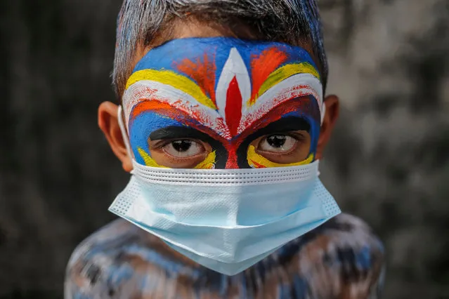 Balinese have their bodies painted and wears protective mask during sacred Ngerebeg ritual amid COVID-19 pandemic at Tegallalang Village in Gianyar, Bali, Indonesia on May 19 2021. Ngerebeg is a sacred ritual held every six month which is believed to expel bad luck and evil spirits. The participants decorates their bodies with colourful paints and accessories to symbolise astral beings while marching across the village. (Photo by Johanes Christo/NurPhoto/Rex Features/Shutterstock)