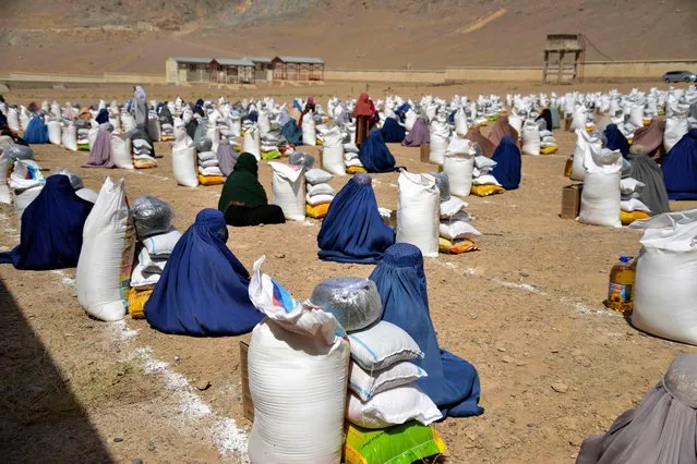 Afghan burqa-clad women receive food from foreign aid in Kandahar on August 10, 2023. (Photo by Sanaullah Seiam/AFP Photo)