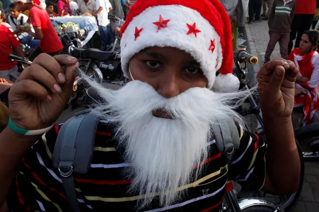 A boy wears Santa Claus' hat and beard as he reacts to camera during a peace rally ahead of Christmas celebrations in Karachi, Pakistan December 21, 2016. (Photo by Akhtar Soomro/Reuters)