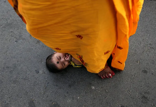 A Hindu woman steps over an infant in a ritual seeking blessings for the infant from the Sun god during the religious festival of Chhath Puja in Kolkata, India, November 13, 2018. (Photo by Rupak De Chowdhuri/Reuters)