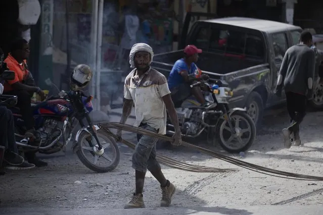 A worker carries steel rebar for a construction project a day after the murder of President Jovenel Moise, in Port-au-Prince, Haiti, Thursday, July 8, 2021. (Photo by Joseph Odelyn/AP Photo)