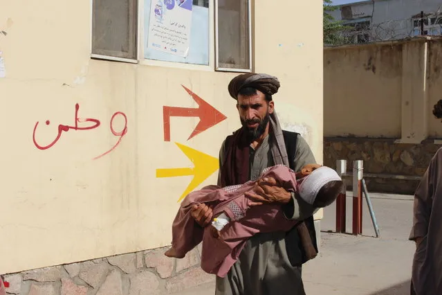 An Afghan civilian carry a wounded child to the hospital after he was injured during fighting between Taliban and government in Badghis province, northwest of Afghanistan, Wednesday, July, 7 2021. From the early hours of Wednesday morning, battles have raged near the provincial police headquarters and a Qala-e-Naw army base, said Abdul Aziz beg, head of the provincial council in Badghis. (Photo by Mirwis Omari/AP Photo)