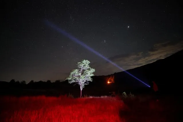 A man uses laser light towards the sky during annual Perseid meteor shower at Shebenik National Park, in Fushe Stude, Albania on August 13, 2023. (Photo by Florion Goga/Reuters)