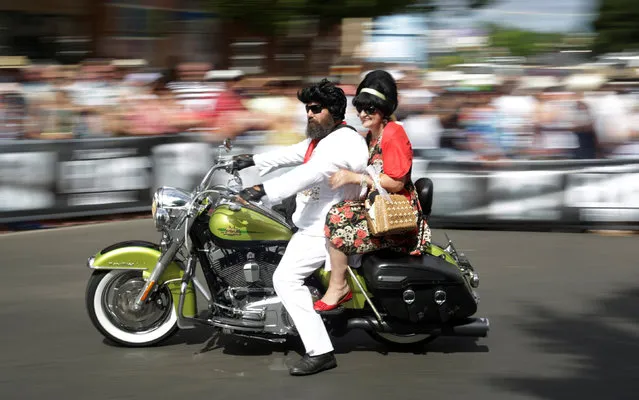 A man dressed as Elvis Presley rides his motorcycle with his passenger during a street parade at the 25th annual Parkes Elvis Festival in the rural Australian town of Parkes, west of Sydney, January 14, 2017. (Photo by Jason Reed/Reuters)