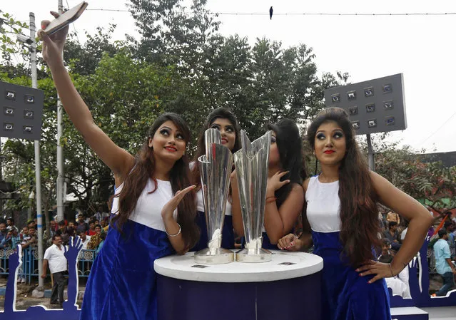 Models take a selfie next to the World Twenty20 trophies after they arrived in Kolkata, India, February 24, 2016. The two tournaments, Men's World Twenty20 and Women's World Twenty20 are scheduled to start on March 8 and March 15 respectively. (Photo by Rupak De Chowdhuri/Reuters)