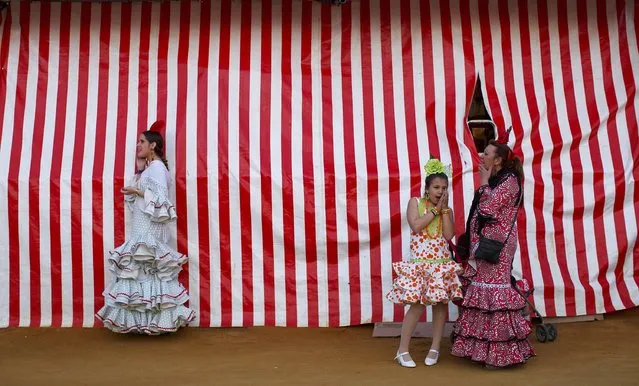 Women wearing sevillana dresses are seen during the traditional Feria de Abril (April fair) in the Andalusian capital of Seville, southern Spain, April 23, 2015. (Photo by Marcelo del Pozo/Reuters)