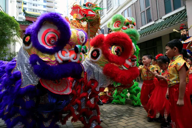 Filipino-Chinese students look at lion and dragon dancers after performing traditional dances ahead of the Lunar New Year celebrations at Lucky Chinatown Mall in Binondo city, metro Manila, Philippines January 26, 2017. (Photo by Romeo Ranoco/Reuters)
