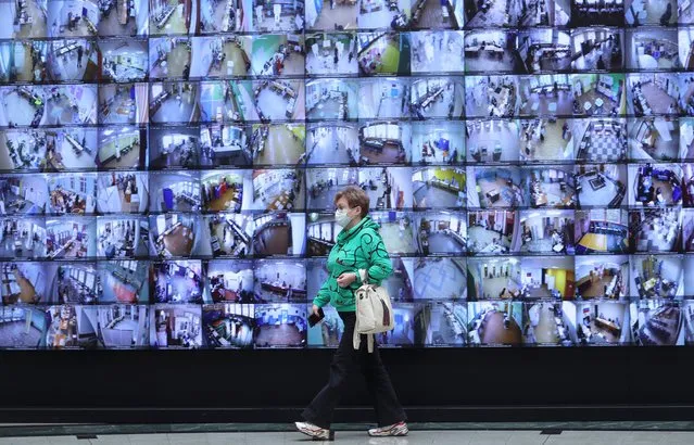 A woman walks past electronic screens showing a live broadcast from polling stations at the headquarters of Russia's Central Election Commission during a three-day parliamentary election in Moscow, Russia on September 17, 2021. (Photo by Evgenia Novozhenina/Reuters)
