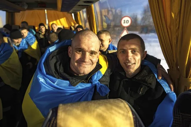 Recently swapped Ukrainian prisoners of war covered in national flags sit in a bus after a prisoner exchange on the Ukrainian Russian border, on Wednesday, January 31, 2024. Russia and Ukraine have exchanged about 200 prisoners of war each, the countries said Wednesday, despite tensions stemming from last week's crash of a military transport plane that Moscow claimed was carrying Ukrainian POWs and was shot down by Kyiv's forces. (Photo by Danylo Pavlov/AP Photo)