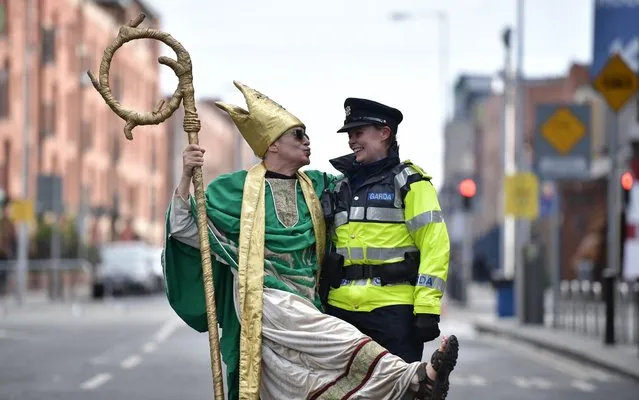 A reveller poses with a policewoman on March 17, 2019 in Dublin, Ireland. Saint Patrick, the patron saint of Ireland is celebrated around the world on St. Patrick's Day. According to legend Saint Patrick used the three-leaved shamrock to explain the Holy Trinity to Irish pagans in the 5th-century after becoming a Christian missionary. (Photo by Charles McQuillan/Getty Images)