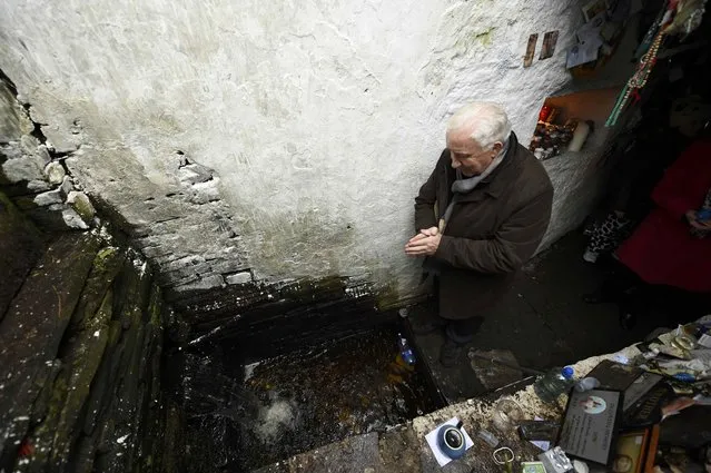 A man prays at the holy well of St. Brigid on a Pattern Day pilgrimage to St. Brigid in Liscannor, Ireland February 1, 2017. (Photo by Clodagh Kilcoyne/Reuters)