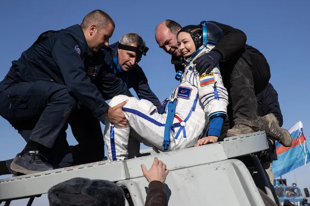 Ground personnel tend to actress Yulia Peresild after the landing of the Soyuz MS-18 reentry capsule with herself and director Klim Shipenko of the “Vyzov” (The Challenge) film crew as well as Roscosmos cosmonaut Oleg Novitsky on board, in steppes southeast of Jezkazgan, Kazakhstan on October 17, 2021. (Photo by Sergei Savostyanov/TASS)