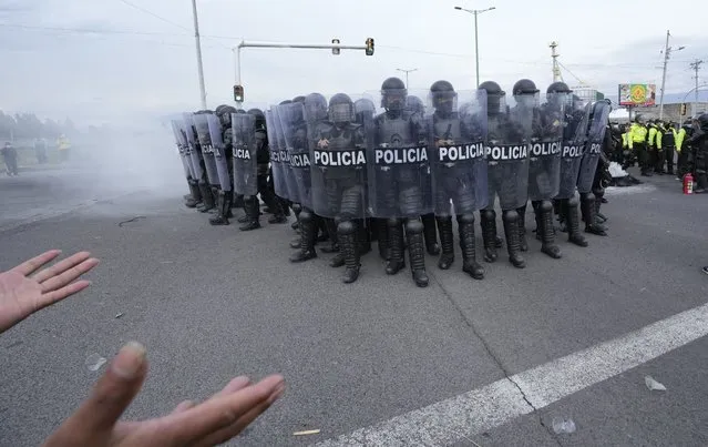 Police advance on a group of protesters on the first day of a general, nation-wide strike to protest the rise in gas prices and the policies of Ecuador's President Guillermo Lasso, in Saquisili, Ecuador, Tuesday, October 26, 2021. (Photo by Dolores Ochoa/AP Photo)