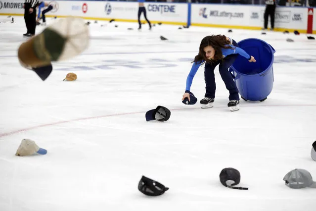 A member of the St. Louis Blues ice crew picks up caps after Blues' Jaden Schwartz scored a hat trick during the third period in Game 6 of an NHL first-round hockey playoff series against the Winnipeg Jets, Saturday, April 20, 2019, in St. Louis. (Photo by Jeff Roberson/AP Photo)