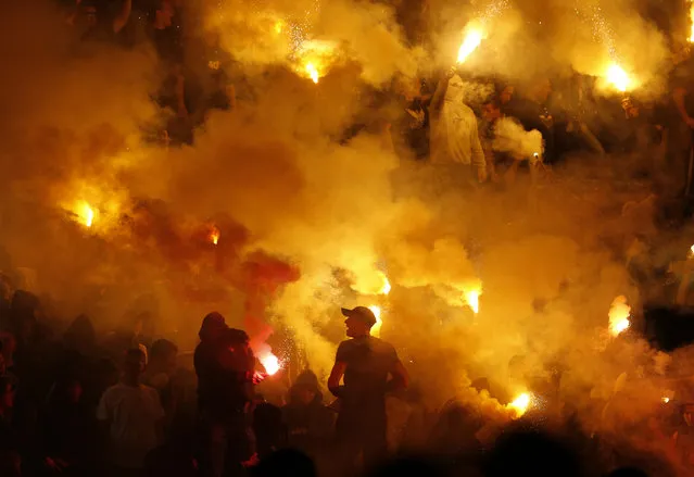 Partizan soccer fans light torches during a Serbian National soccer league derby match between Red Star and Partizan, in Belgrade, Serbia, Saturday, April 25, 2015. (Photo by Darko Vojinovic/AP Photo)