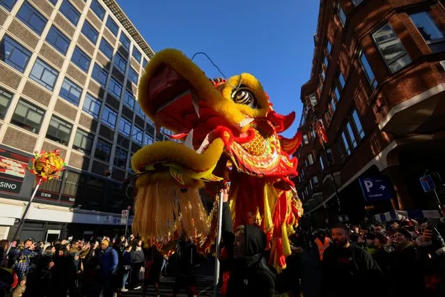 People march through a street during celebrations on the first day of the Lunar New Year in London, Britain on January 22, 2023. (Photo by Toby Melville/Reuters)