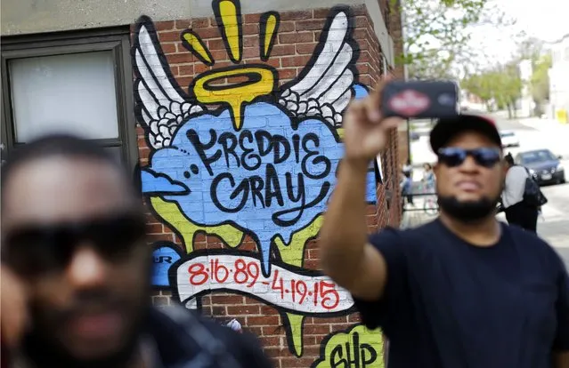 J.R. White, right, takes a selfie in front of a mural that was painted at the site of Freddie Gray's arrest, Saturday, May 2, 2015, in Baltimore, as protesters prepare to march to City Hall. (Photo by Patrick Semansky/AP Photo)