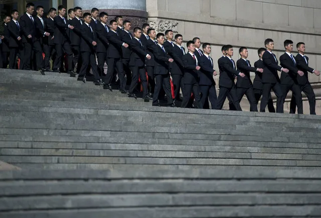 Chinese soldiers dressed as ushers march out from the Great Hall of the People where sessions of the National People's Congress and Chinese People's Political Consultative Conference are being held in Beijing, China Tuesday, March 4, 2014. (Photo by Andy Wong/AP Photo)
