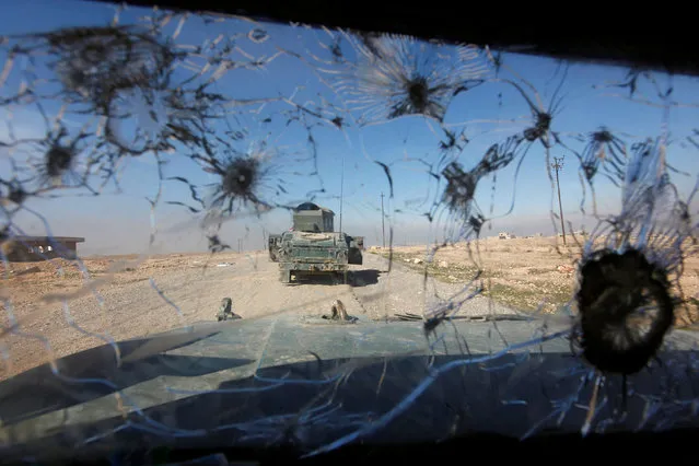 Iraqi rapid response forces advancing towards south of Mosul are seen through a shattered glass window of a military vehicle, Iraq February 20, 2017. (Photo by Alaa Al-Marjani/Reuters)