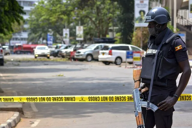 Security forces secure the scene of a blast on a street near the parliamentary building in Kampala, Uganda, Tuesday, November 16, 2021. Two loud explosions rocked Uganda's capital, Kampala, early Tuesday, sparking chaos and confusion as people fled what is widely believed to be coordinated attacks. (Photo by Hajarah Nalwadda/AP Photo)