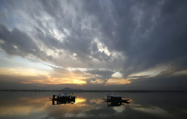 Sun sets in the backdrop of still boats in the waters of Dal Lake in Srinagar, the summer capital of Indian Kashmir, 23 March 2016. (Photo by Farooq Khan/EPA)