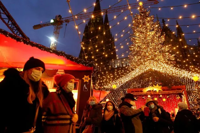 People visit a Christmas market next to Cologne Cathedral as the spread of the coronavirus disease (COVID-19) continues in Cologne, Germany, December 1, 2021. (Photo by Thilo Schmuelgen/Reuters)
