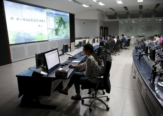 Staff members of the Beijing Municipal Environmental Protection Monitoring Center work in a monitoring room of the air quality forecast and warning center in Beijing, China, May 21, 2015. (Photo by Kim Kyung-Hoon/Reuters)