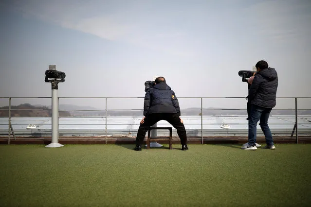 Tourists look toward the north through binoculars near the demilitarized zone separating the two Koreas in Paju, South Korea, February 27, 2019. (Photo by Kim Hong-Ji/Reuters)