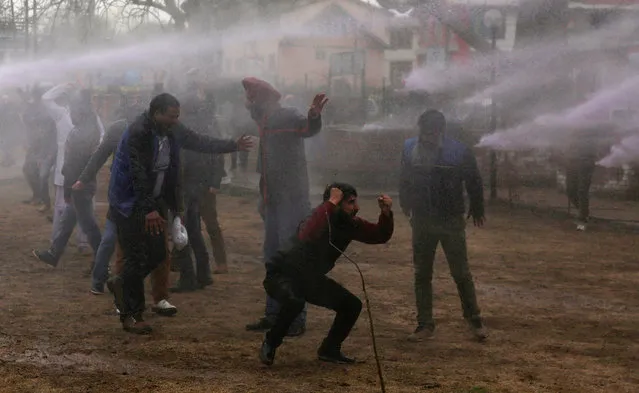 Contractual employees of the National Health Mission (NHM) shout slogans as Indian police spray purple colored water from a water canon to disperse them during a protest in Srinagar, the summer capital of Indian Kashmir, 07 March 2017. Indian police used cane charge, tear shells, water cannons and detained some of NHM employees while they were demanding regularization of their services. (Photo by Farooq Khan/EPA)