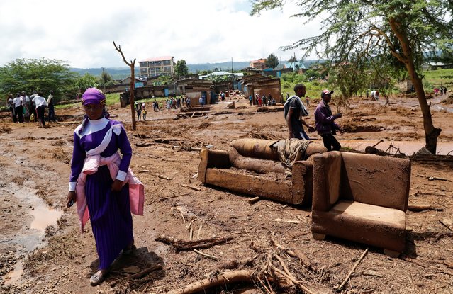 A woman walks past couches that were washed away after heavy flash floods wiped out several homes when a dam burst, following heavy rains in Kamuchiri village of Mai Mahiu, Nakuru County, Kenya on April 29, 2024. (Photo by Thomas Mukoya/Reuters)