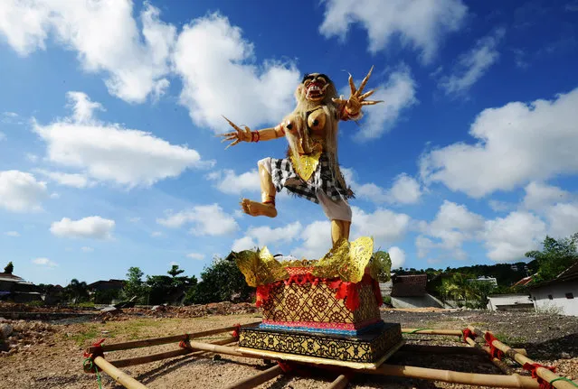 An effigy known as “Ogoh-ogoh” symbolising evil is displayed in a field in the residential area in Jimbaran district as the Indonesian holiday island shut down for a day of silence to mark Nyepi, the Hindu new year on March 31, 2014. Retailers closed their shops and many tourists stayed inside their hotels for a day of reflection that is supposed to be free from daily routine, including work and play. Guards with sticks and traditional daggers enforced the public observance among the Hindu- majority population. (Photo by Sonny Tumbelaka/AFP Photo)