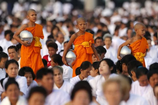 Buddhist novices walk as they gather alms at Wat Phra Dhammakaya temple, in what organizers said was a meeting of over 100,000 monks in Pathum Thani, outside Bangkok April 22, 2016. (Photo by Jorge Silva/Reuters)