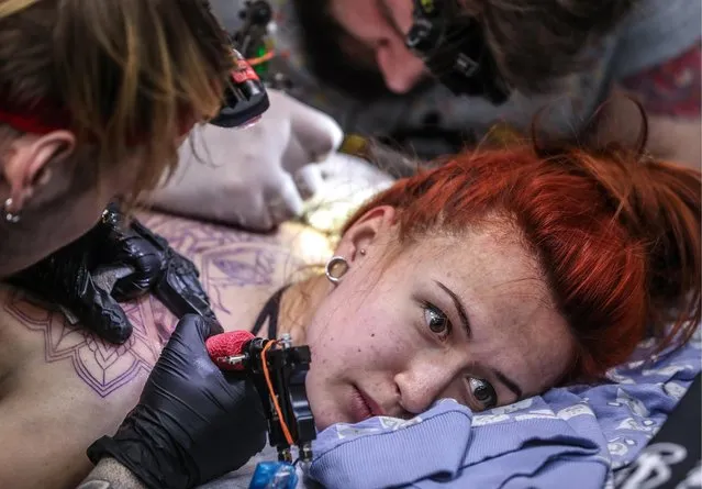 A tattoo artist applying ink during the 2017 Moscow Tattoo Festival at Moscow' s Amber Plaza Shopping Center in Moscow, Russia on April 1, 2017. (Photo by Valery Sharifulin/TASS)