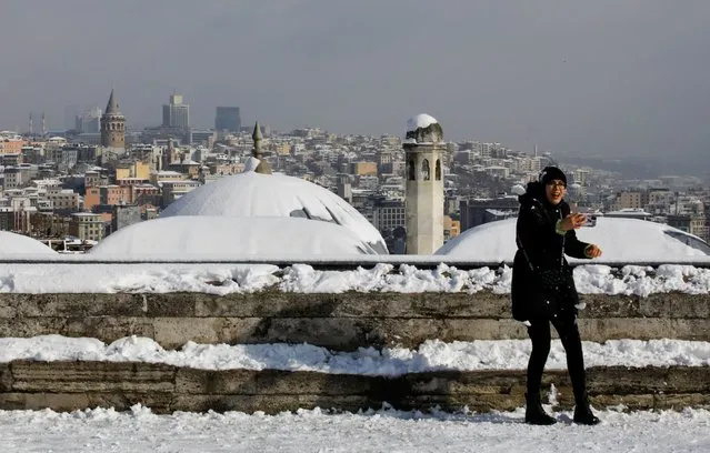 A woman enjoys a snowy day at the garden of Suleymaniye Mosque in Istanbul, Turkey, January 24, 2022. (Photo by Umit Bektas/Reuters)