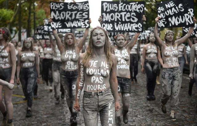 Leader of the feminist activist group Femen Inna Shevchenko (front) and Femen activists hold placards reading “More heard dead than alive”, “I didn't want to die” during a protest action dedicated to the memory of the women killed by their partner or ex-partner and against the violence against women, at the cemetery of Montparnasse in Paris, on October 5, 2019. 114 women have been killed by their partner or ex-partner since the beginning of 2019 in France, according to the “Feminicides par compagnons ou ex” (Feminicides by companions or ex) association. (Photo by Lucas Barioulet/AFP Photo)
