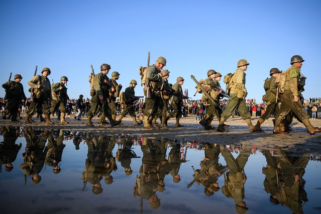 Enthusiasts dressed in replica US Army WWII-era military attire parade along Utah Beach on June 6, 2024 as part of the “D-Day” commemorations marking the 80th anniversary of the World War II Allied landings in Normandy. The D-Day ceremonies on June 6 this year mark the 80th anniversary since the launch of “Operation Overlord”, a vast military operation by Allied forces in Normandy, which turned the tide of World War II, eventually leading to the liberation of occupied France and the end of the war against Nazi Germany. (Photo by Loic Venance/AFP Photo)