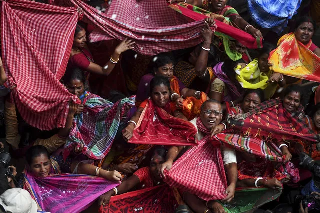Hindu devotees collect rice as offerings distributed by the temple authority on the occasion of the “Annakut” or “Govardhan Puja” festival at the Madan Mohan temple in  Kolkata on October 29, 2019. People in large numbers gather at the temple and collect the rice offerings in the belief that the rice will keep them in good condition and never in life will they face poverty or scarcity of food. (Photo by Dibyangshu Sarkar/AFP Photo)