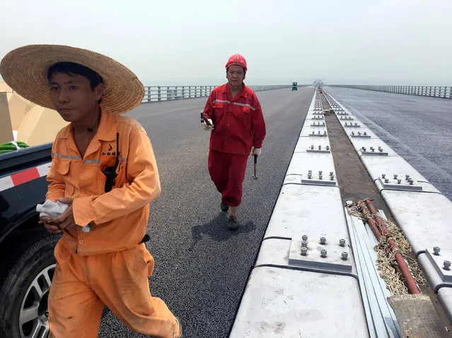 Workers walk on the Hong Kong-Zhuhai-Macau bridge under construction in Zhuhai, China May 17, 2017. Picture taken May 17, 2017. (Photo by James Pomfret/Reuters)