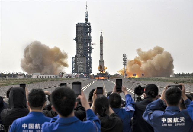 Members from China's Manned Space Agency and visitors watch as the Shenzhou-16 spacecraft onboard the Long March-2F rocket launches at the Jiuquan Satellite Launch Center on May 30, 2023 in Jiuquan, China. The three astronaut crew of the Shenzhou-16 spacecraft will be carried to China's new Tiangong Space Station and will replace a similar crew that have been at the station for the last six months. (Photo by Kevin Frayer/Getty Images)