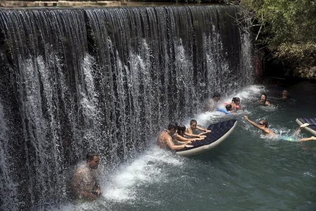 People cool off in the water of the Gan HaShlosha National Park, also known by its Arabic name Sahne, near the town of Beit Shean in the Jordan valley August 5, 2015. Israel has been sweltering for the past several days under extremely hot temperatures and oppressive humidity, registering record electricity consumption to power air conditioners. (Photo by Baz Ratner/Reuters)