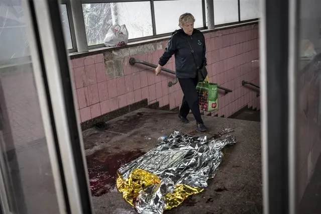 A woman walks past broken glass and blood after shelling in Kharkiv, eastern Ukraine, Thursday, May 26, 2022. (Photo by Bernat Armangue/AP Photo)