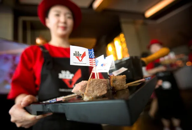 A hostess holds a tray of sliced American beef at an event to celebrate the re-introduction of American beef imports to China, in Beijing, China June 30, 2017. (Photo by Mark Schiefelbein/Reuters)