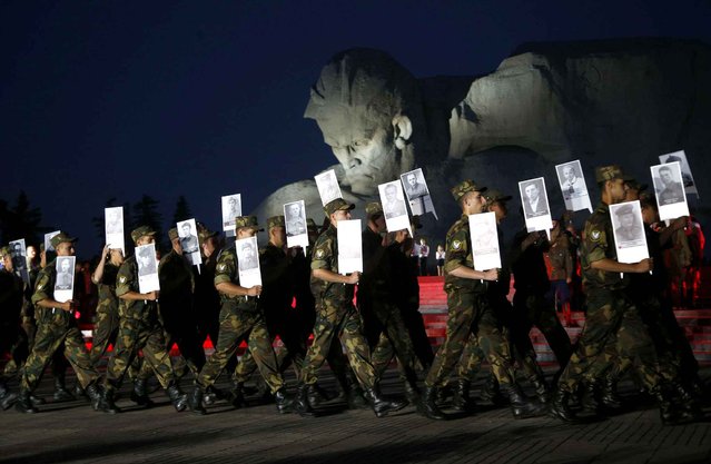 Soldiers of Belarusian army carry portraits of fortress' defenders in front of the most important Soviet WWII war monuments during a ceremony to mark the Day of Remembrance and Sorrow, on the 75th anniversary of Germany's attack on the Soviet Union in World War II in the Brest Fortress memorial, 360 kilometers (225 miles) southwest of Minsk, Belarus, early Wednesday, June 22, 2016. The garrison of the 19-century fortress was encircled hours after the Nazis invaded the Soviet Union on June 22, 1941, but the Brest fortress' Soviet defenders held out for 28 days. (Photo by Sergei Grits/AP Photo)
