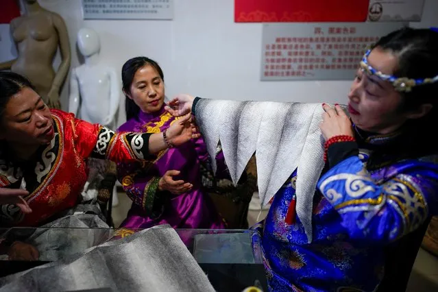 Ethnic Hezhen You Wenfeng's Chinese Han students learn how to make clothes from fish skin at You's studio in Tongjiang, Heilongjiang province, China December 31, 2019. The education is arduous, with You's acolytes committing to memory songs of fishing, hunting and ancient tribal conquests through phonetics alone. With little prompting, You burst into song in her studio apartment during a visit by Reuters, singing of a woman's wish to bear a son for her hunter-husband. (Photo by Aly Song/Reuters)
