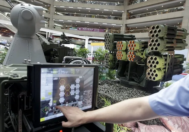 A man demonstrates the Taiwan-made coastal defense rocket system at the Taipei World Trade Centre during the 2015 Taipei Aerospace and Defense Technology Exhibition, August 12, 2015. (Photo by Pichi Chuang/Reuters)