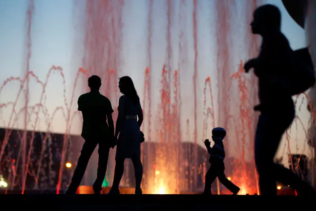 People are silhouetted in front of a musical fountain at the Millennium Square in Saransk, Russia on July 15, 2017. (Photo by David Mdzinarishvili/Reuters)